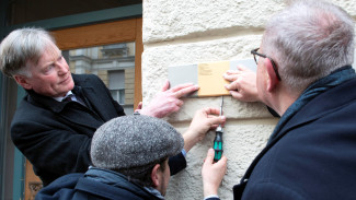 Björn Mensing, Maximilian Strnad und Stadtrat Beppo Brem bringen das Erinnerungszeichen an, Foto Kulturreferat der Landeshauptstadt München